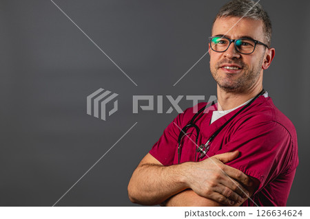 Healthcare professional with glasses poses confidently in scrubs indoors Healthcare professional with glasses poses confidently in scrubs indoors 126634624