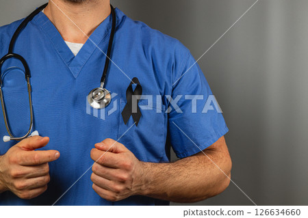 Medical professional wearing blue scrubs and a black ribbon in tribute 126634660
