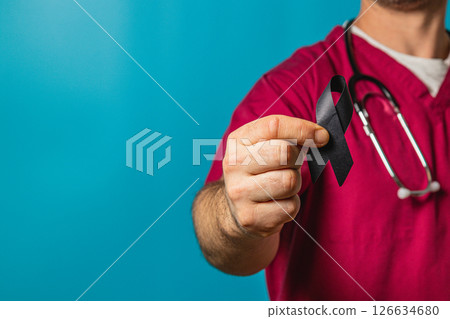 Healthcare professional displays black ribbon to raise awareness in support 126634680