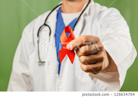 Medical professional holds red ribbon to promote awareness and support Medical professional holds red ribbon to promote awareness and support 126634704