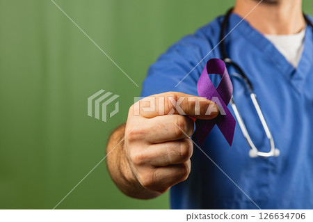 Healthcare professional holds purple awareness ribbon in medical setting 126634706