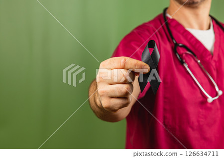 Healthcare worker holds black ribbon to raise awareness in a hospital Healthcare worker holds black ribbon to raise awareness in a hospital 126634711