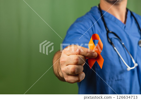Healthcare worker holds orange ribbon to raise awareness for cancer support Healthcare worker holds orange ribbon to raise awareness for cancer support 126634713