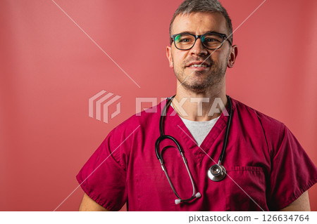 Confident male healthcare professional smiling while wearing scrubs 126634764