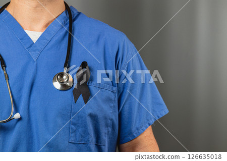 Medical professional wearing blue scrubs and a black ribbon for remembrance Medical professional wearing blue scrubs and a black ribbon for remembrance 126635018