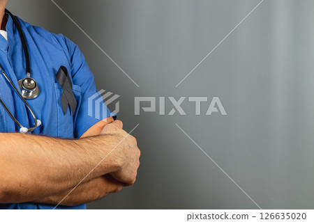 Medical professional wearing blue scrubs with a black ribbon in tribute Medical professional wearing blue scrubs with a black ribbon in tribute 126635020