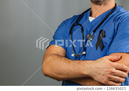 Healthcare worker shows solidarity with black ribbon on scrubs Healthcare worker shows solidarity with black ribbon on scrubs 126635021