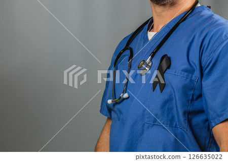 Medical professional wearing blue scrubs and a black ribbon in solidarity Medical professional wearing blue scrubs and a black ribbon in solidarity 126635022