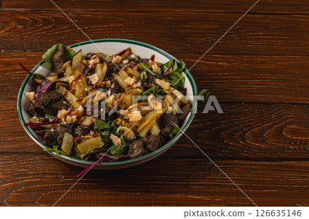 Fresh salad with meat and vegetables served on wooden table 126635146