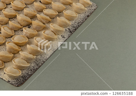 Traditional dumplings being prepared on a wooden board Traditional dumplings being prepared on a wooden board 126635188