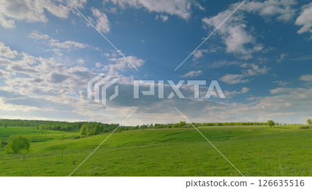 Majestic Scenic Green Hills Beneath a Bright Blue Sky Filled with Fluffy White Clouds Time lapse. 126635516
