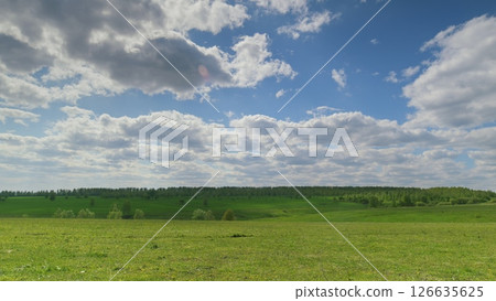A Lush Green Meadow Beautifully Positioned Under a Cloudy and Overcast Sky Expansively Time lapse. A Lush Green Meadow Beautifully Positioned Under a Cloudy and Overcast Sky Expansively Time lapse. 126635625