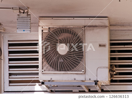 Dusty air conditioner unit on building facade 126636313