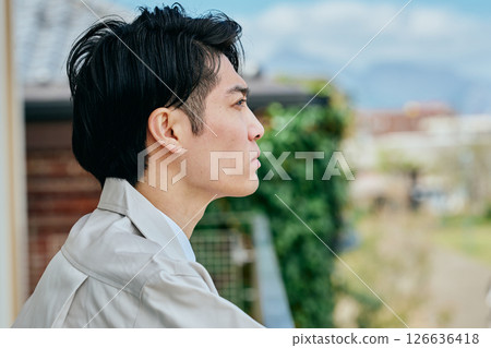 A young man in work clothes looking outside 126636418