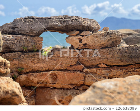 A hole in ancient stonework. Ruins of a historical burial - Necropolis de Son Real in Alcudia, Mallorca 126638099