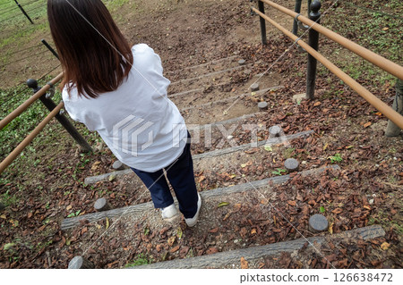 A woman descending a wooden staircase A woman descending a wooden staircase 126638472
