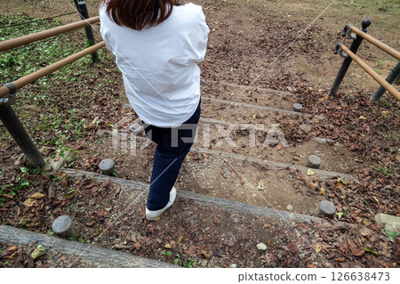 A woman descending a wooden staircase A woman descending a wooden staircase 126638473