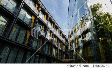 Contemporary building design showcases reflective glass and colorful curtains 126638789