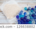 Refreshing blue marbles and sea sand - summer image 126638802