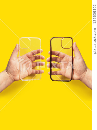 Transparent phone case comparison showing clean and dirty versions held in hands against bright yellow background, illustrating the impact of daily use on phone accessories Transparent phone case comparison showing clean and dirty versions held in hands against bright yellow background, illustrating the impact of daily use on phone accessories 126639302