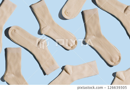 Pattern of cream-colored ribbed socks on light blue background. Concept of socks texture and design for fashion and textile applications Pattern of cream-colored ribbed socks on light blue background. Concept of socks texture and design for fashion and textile applications 126639305
