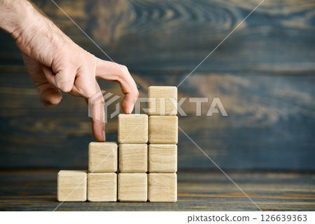 Wooden blocks stacked as blue arrow bar chart 126639363