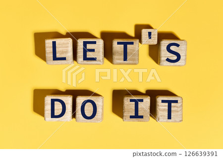 Let's do it motivation phrase on wooden blocks over yellow background 126639391