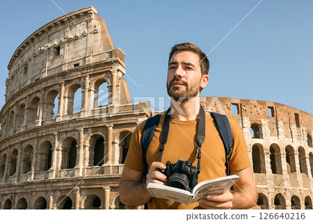 Caucasian male tourist with camera and guidebook exploring ancient stone ruins on sunny day in european city. Concept of cultural travel, sightseeing adventure, historical exploration 126640216