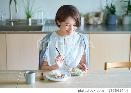 Female eating breakfast in the room 126641444