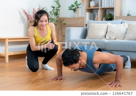 Young asian couple workout during woman hold smartphone encouragement to partner. 126641767