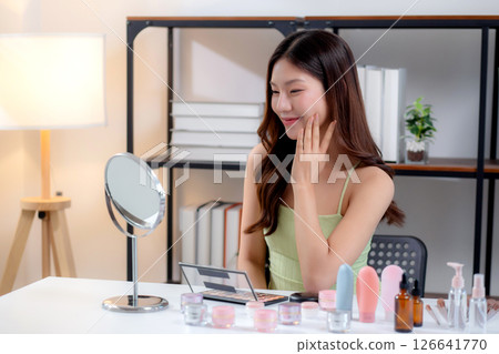 Beauty young asian woman looking mirror for check wrinkles on facial in living room at home. Beauty young asian woman looking mirror for check wrinkles on facial in living room at home. 126641770