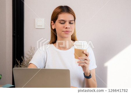 Happiness young caucasian businesswoman drinking coffee while working on laptop computer. Happiness young caucasian businesswoman drinking coffee while working on laptop computer. 126641782
