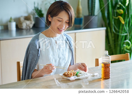 一位女士正在吃外帶午餐 126642058