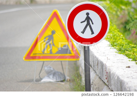 Construction zone sign is next to a pedestrian crossing sign 126642198