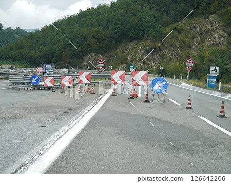Road with a lot of orange cones and signs Road with a lot of orange cones and signs 126642206