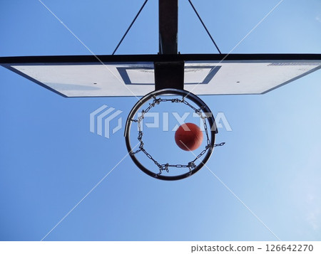 Basketball is in the air, about to go through a hoop 126642270