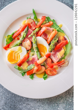 Elegant Nicoise portion with eggs, tuna, arugula, asparagus, cherry tomatoes, white plate Elegant Nicoise portion with eggs, tuna, arugula, asparagus, cherry tomatoes, white plate 126642291