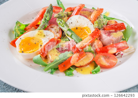 Elegant Nicoise portion with eggs, tuna, arugula, asparagus, cherry tomatoes, white plate Elegant Nicoise portion with eggs, tuna, arugula, asparagus, cherry tomatoes, white plate 126642293