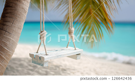 Wooden swing hanging from palm tree overlooking tropical beach with turquoise waters Wooden swing hanging from palm tree overlooking tropical beach with turquoise waters 126642436