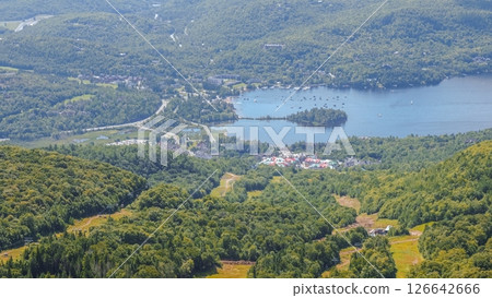 Aerial View of a Charming Mountain Town Surrounded by Lush Green Peaks and a Serene Lake Aerial View of a Charming Mountain Town Surrounded by Lush Green Peaks and a Serene Lake 126642666