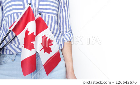 Unrecognized girl student in white blue shirt holding small Canadian flag over gray background, Canada day, holiday, vote, immigration, tax, copy space Unrecognized girl student in white blue shirt holding small Canadian flag over gray background, Canada day, holiday, vote, immigration, tax, copy space 126642670