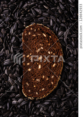 Slice of rye bread on black seed background 126642933
