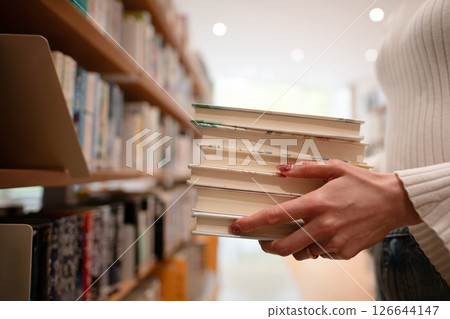 Woman's hand choosing a book 126644147