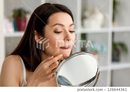 Woman Checking Pimple on Chin in Mirror 126644361