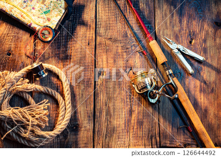 Fishing screensaver. Rod and fishing gear. Hobbies and recreation. Active recreation. Items for fishing. Wooden background. 126644492