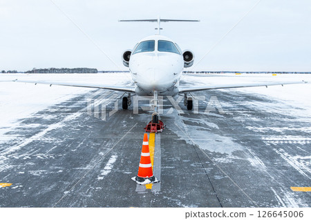 Front view of the white private aircraft at winter airport 126645006