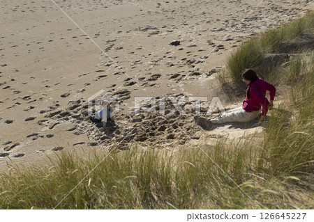 Mother and son playing on the beach on a sunny day Mother and son playing on the beach on a sunny day 126645227