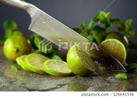 Knife, slices of lime and sprigs of fresh mint. Knife, slices of lime and sprigs of fresh mint. 126645596