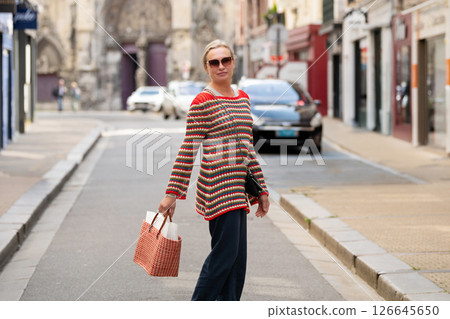 Blonde woman with glasses and a straw bag walking and shopping at the Dieppe market 126645650