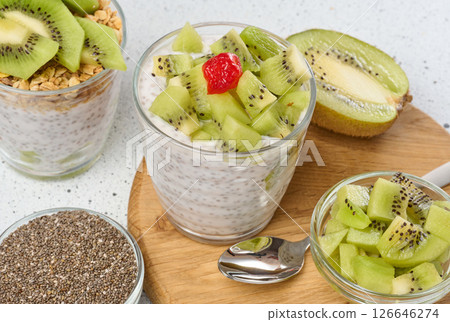 A glass of chia seed pudding layered with kiwi and granola, topped with kiwi slices A glass of chia seed pudding layered with kiwi and granola, topped with kiwi slices 126646274